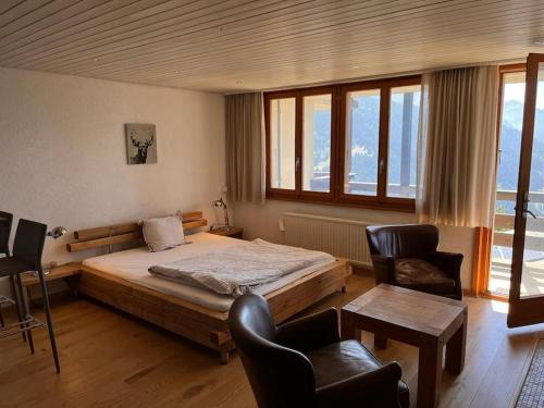 a bedroom with a large bed and two chairs at Alpe des chaux 61 03 in Gryon