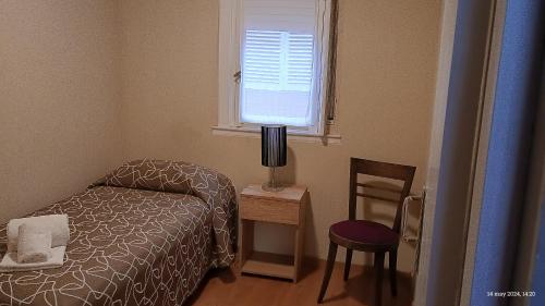 a small bedroom with a bed and a window at Hotel Hawaii in Mar del Plata