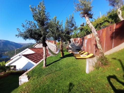 a backyard with a hammock and two trees at Romoa - Gerês & Cabreira in Vieira do Minho