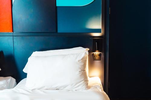 a bed with a white pillow next to a blue wall at Kabannas Liverpool in Liverpool