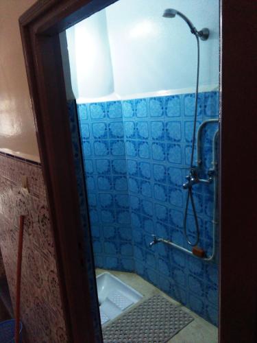 a bathroom with a shower with blue tiles on the wall at Private Room - 23 Min to Airport - 20 Min to Agadir Beach - Near Golf, Medina, Markets & Inezgane Taxi Station for Nearby Visits and City-to-City Travel in Inezgane