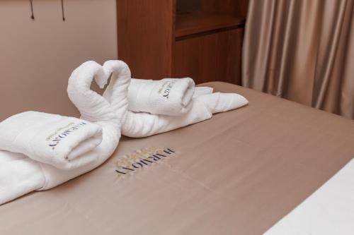 a pile of towels sitting on top of a bed at Harmony Boutique Hotel in Vlorë