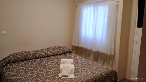 a bedroom with a bed with two towels on it at Hotel Hawaii in Mar del Plata