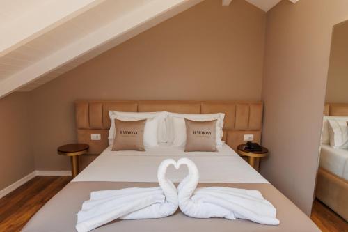 two swans made out of towels sitting on a bed at Harmony Boutique Hotel in Vlorë