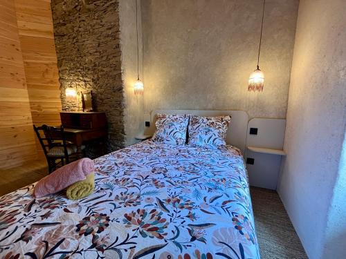 une chambre avec un lit avec une couette bleue dans l'établissement Parenthèse en forêt - Lodge BALIVEAU, à Le Bez