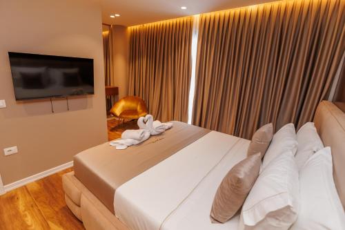 a hotel room with a bed and a television at Harmony Boutique Hotel in Vlorë