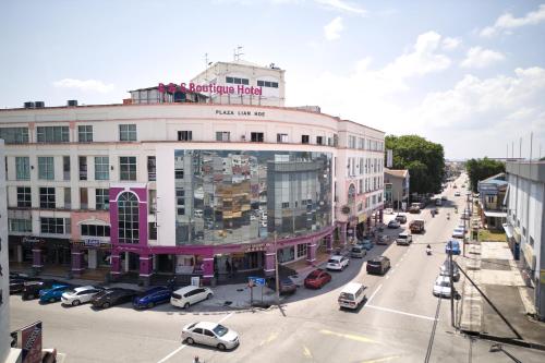 a city street with cars parked in front of a building at B&S Boutique Hotel in Batu Pahat