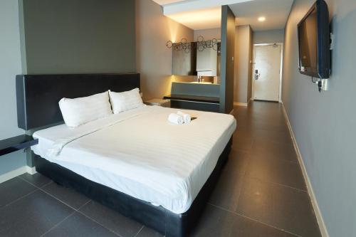 a bedroom with a large white bed and a television at B&S Boutique Hotel in Batu Pahat