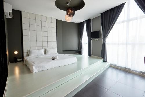 a bedroom with a white bed and a large window at B&S Boutique Hotel in Batu Pahat