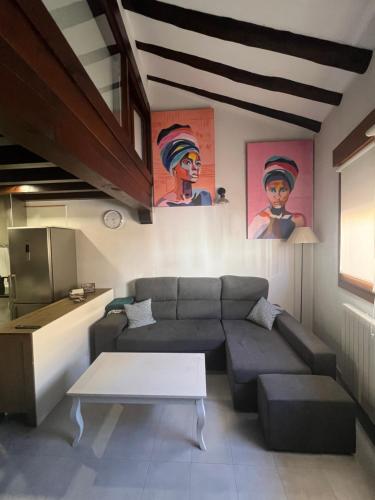 a living room with a couch and a table at Apartamento dúplex en Sangüesa de 3 dormitorios y 2 baños in Sangüesa