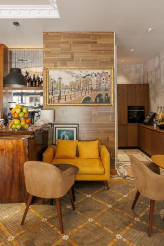 a living room with a yellow couch and chairs at Harmony Boutique Hotel in Vlorë