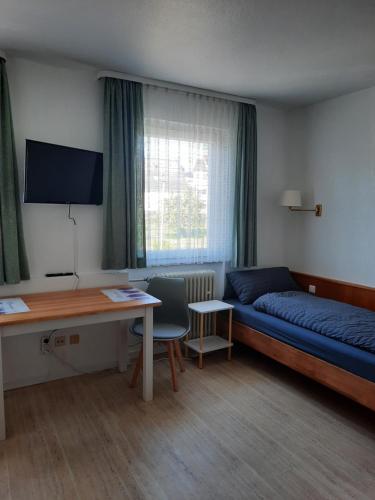 a room with a bed and a desk and a table at Monteurwohnung - Handwerkerwohnung Jesse Bad König in Bad König