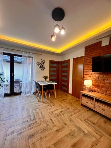 a living room with a table and a tv at Domek pod Tatrami Jurgów noclegi in Jurgów