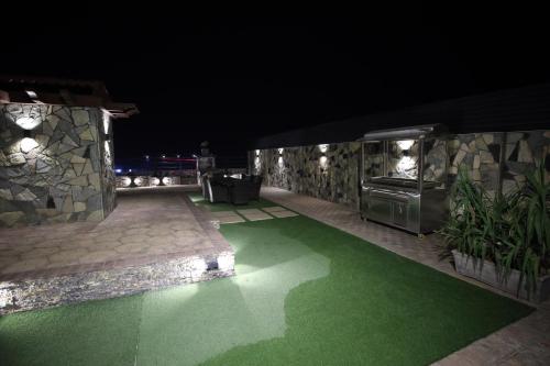 a patio with a green lawn at night at Penthouse in Islamabad by Bella Vista in Islamabad