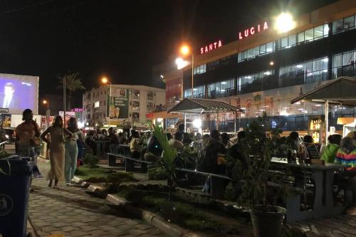 a group of people sitting at tables at night at Studio B4 B-ssadi Santa Lucia wifi canal gardien in Douala