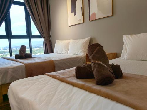 a hotel room with two beds with stuffed animals on them at K Avenue Modern Style Studio (5 Mins to Airport) in Kota Kinabalu