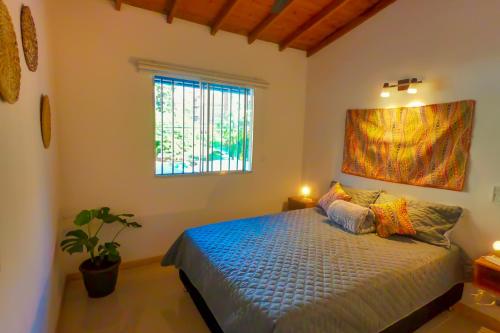 a bedroom with a bed and a window at Azulejo - Guest House in Medellín