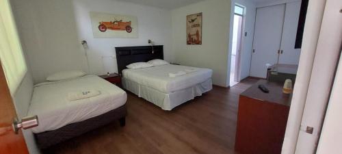 een hotelkamer met twee bedden en een raam bij HOTEL 507 INN in Mejillones