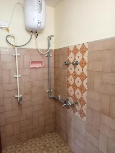 a bathroom with a tiled shower with a toilet at Bhaksaran Home Stay in Tuticorin