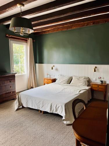 une chambre avec un grand lit et un mur végétal dans l'établissement Maison de campagne rénovée - 15 personnes - 1h30 de Paris - Piscine Pétanque Étang, à Noyers