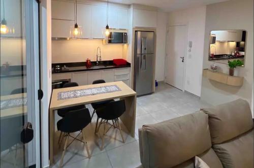 a kitchen and living room with a table and chairs at Apartamento Modernizado in Joinville