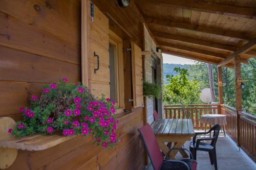 a porch of a cabin with a table and flowers at Top Hill Lodge in Kolašin
