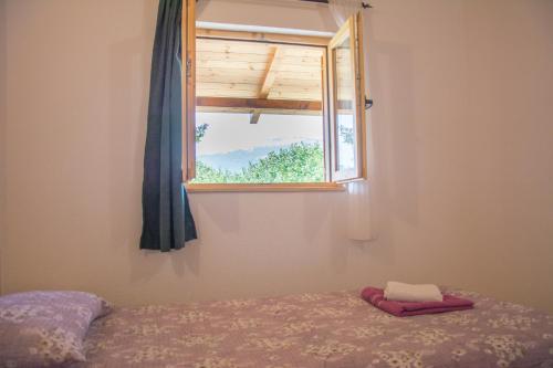 a window in a room with a bed and a window at Top Hill Lodge in Kolašin