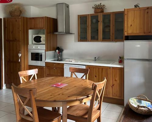 une cuisine avec une table en bois et un réfrigérateur dans l'établissement Appartement chalet 4 pers 45m2 Puy Saint Vincent, à Puy-Saint-Vincent