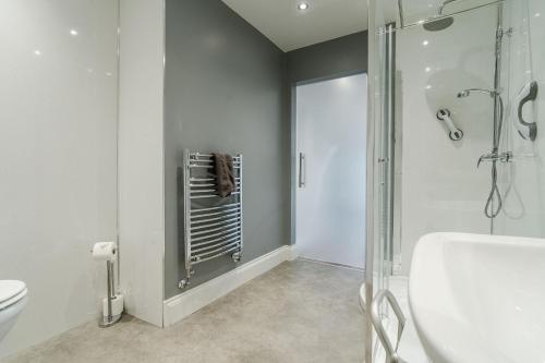 a bathroom with a shower and a toilet and a sink at The Roxburgh Guest Accommodation in Berwick-Upon-Tweed