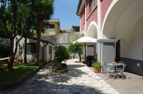 a patio with a table and an umbrella next to a building at La magnolia B&B in Baronissi