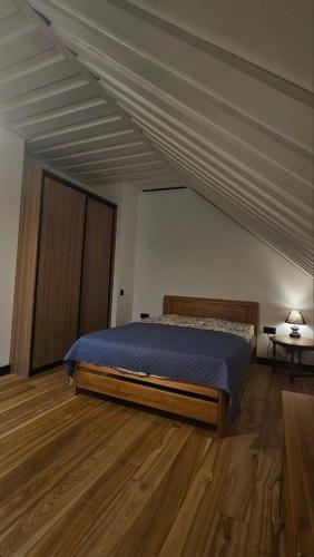 a bedroom with a bed and a wooden floor at More Holiday Cottage L in Bigauņciems