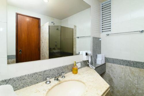 a bathroom with a sink and a mirror at Luix Londrina Flat Hotel, 505, 43 m2, QS, Smart TV in Londrina