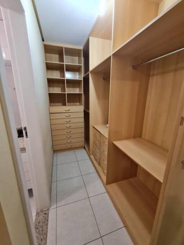 a walk in closet with wooden cabinets and shelves at Burle Marx Centro 4 quart, portaria 24h,área nobre in Montes Claros