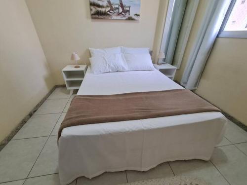 a large bed in a room with two tables at Burle Marx Centro 4 quart, portaria 24h,área nobre in Montes Claros