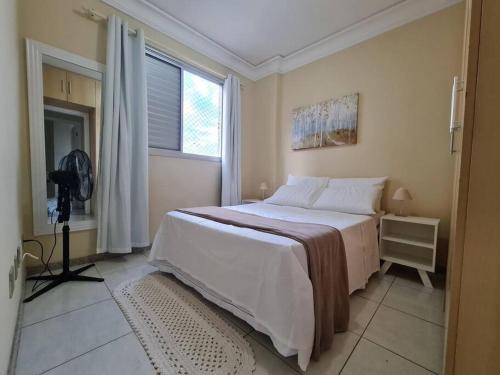 a bedroom with a large bed and a window at Burle Marx Centro 4 quart, portaria 24h,área nobre in Montes Claros
