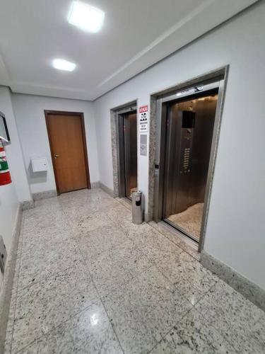 a hallway with two elevators and two doors in a building at Burle Marx Centro 4 quart, portaria 24h,área nobre in Montes Claros