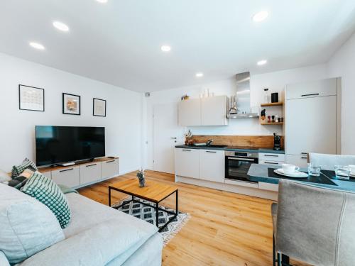 a living room with a couch and a kitchen at Grand Prix Appartement Spielberg, Self Check-in in Zeltweg