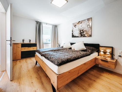 a bedroom with a large bed in a room at Grand Prix Appartement Spielberg, Self Check-in in Zeltweg