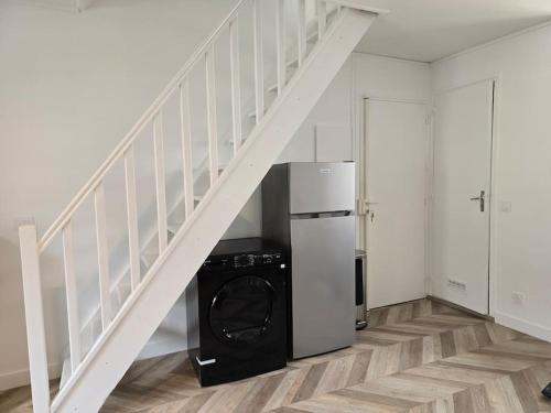 - une buanderie avec un lave-linge et un sèche-linge sous un escalier dans l'établissement Charmant Duplex F2 Disneyland Paris, à Torcy