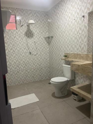 a bathroom with a shower and a toilet and a sink at Pousada Kactus in Piranhas