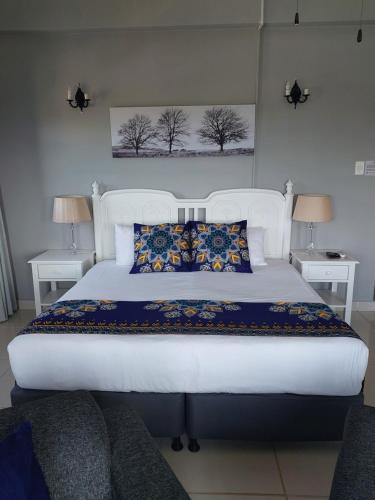 a bedroom with a large white bed with two lamps at Fairway Guest Lodge in Margate