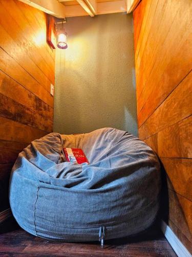 a dog bed with a book on it in a room at Private Cabin- Breakfast - Double Tub - 75in TV - SUP - Washer Dryer - BBQ in West Point