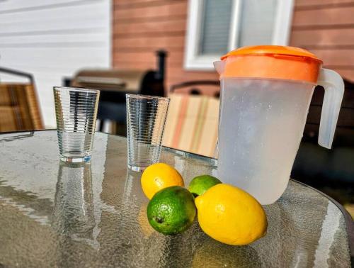 a glass table with lemons and a drink and two cups at Private Cabin- Breakfast - Double Tub - 75in TV - SUP - Washer Dryer - BBQ in West Point