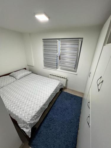 a small bedroom with a bed and a window at Make Apartments in Sarajevo