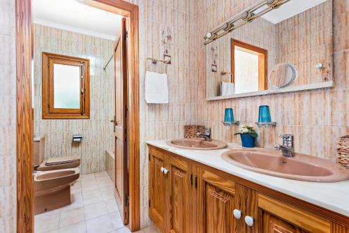 a bathroom with two sinks and a toilet at Binifortu in Punta Prima