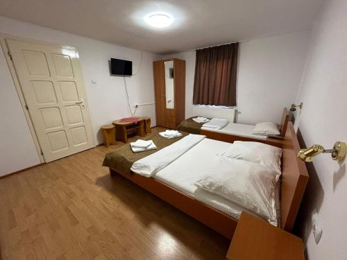 a hotel room with two beds and a door at PENSIUNEA KELEMEN in Praid