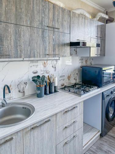 a kitchen with a sink and a washing machine at Oasis Residence Fergana in Fergana