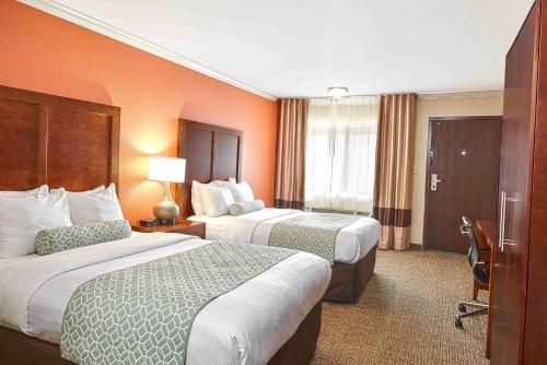 a hotel room with two beds and a desk at The Hills Inn Eagle Rock - Near Old Town Pasadena in Los Angeles