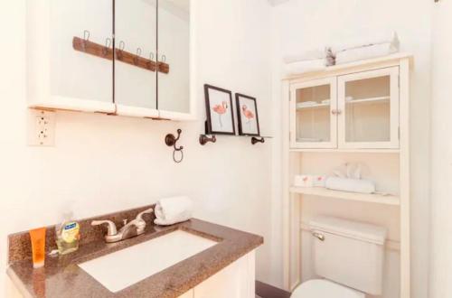 a bathroom with a sink and a toilet at Tropical Waters Hideaway - Pool Tiki & Lounge in Pompano Beach