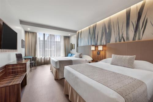 a hotel room with two beds and a flat screen tv at Riu Plaza Chicago in Chicago